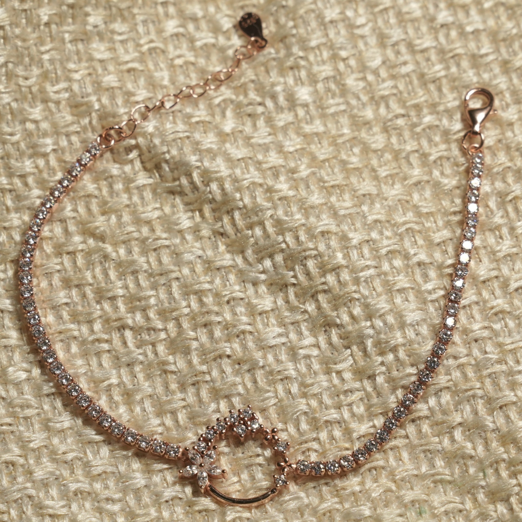 Cubic zirconia tennis bracelet in rose gold-tone sterling silver showing the lobster clasp and extender chain.