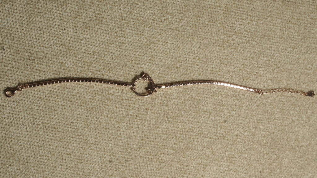 Reverse of the rose gold-tone sterling silver bracelet laid straight, showing the setting backs, wreath outline and teardrop end tag.