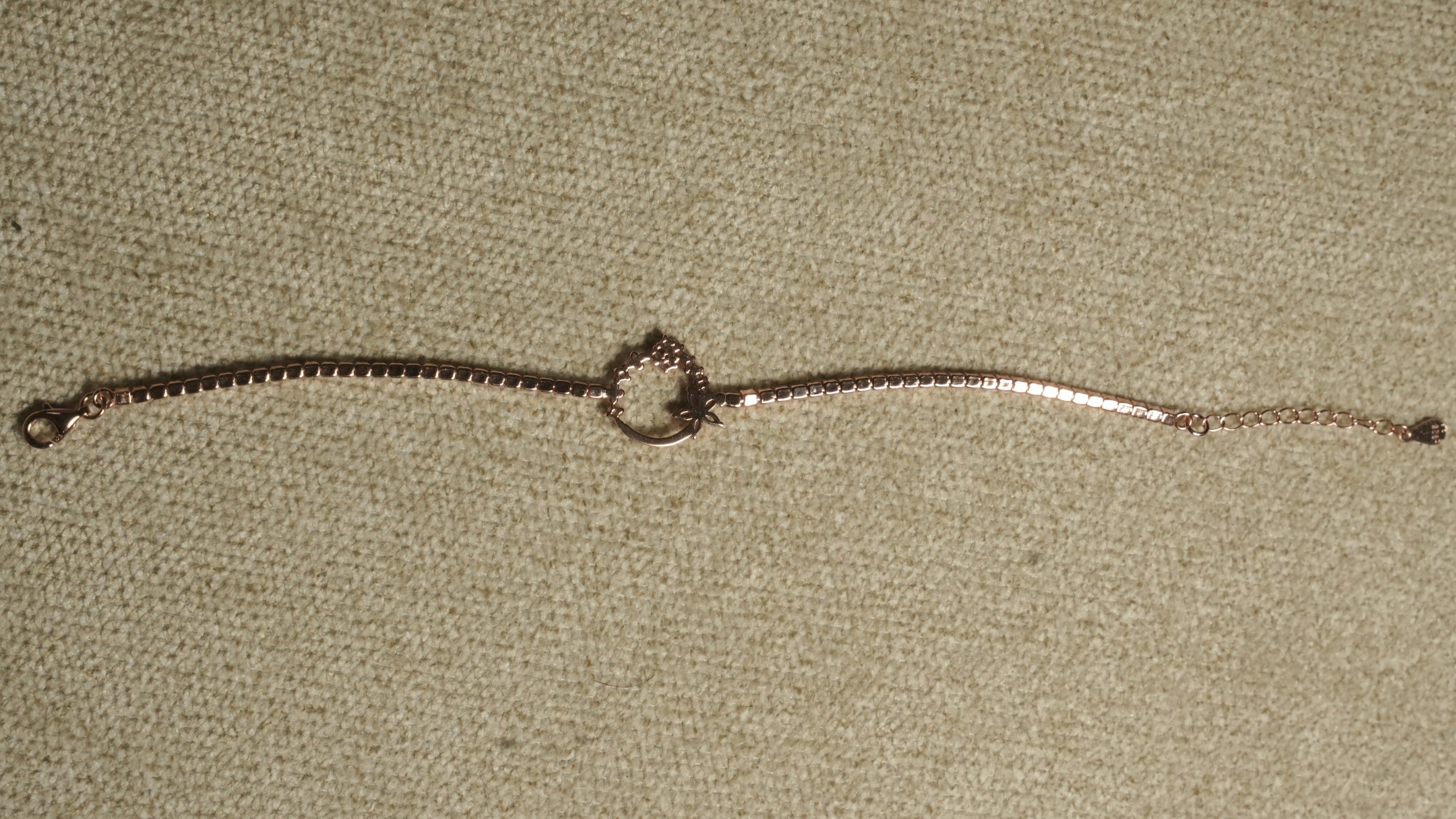 Reverse of the rose gold-tone sterling silver bracelet laid straight, showing the setting backs, wreath outline and teardrop end tag.