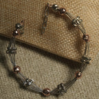 Overhead view of the two-tone beaded bracelet showing grouped fluted silver beads, rose gold-tone orbs and its extender chain.