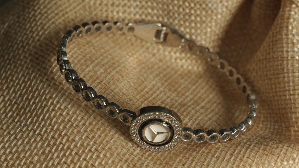 Angled view of the bracelet on a jute pouch, showing the polished open-circle band, hinge and star medallion.
