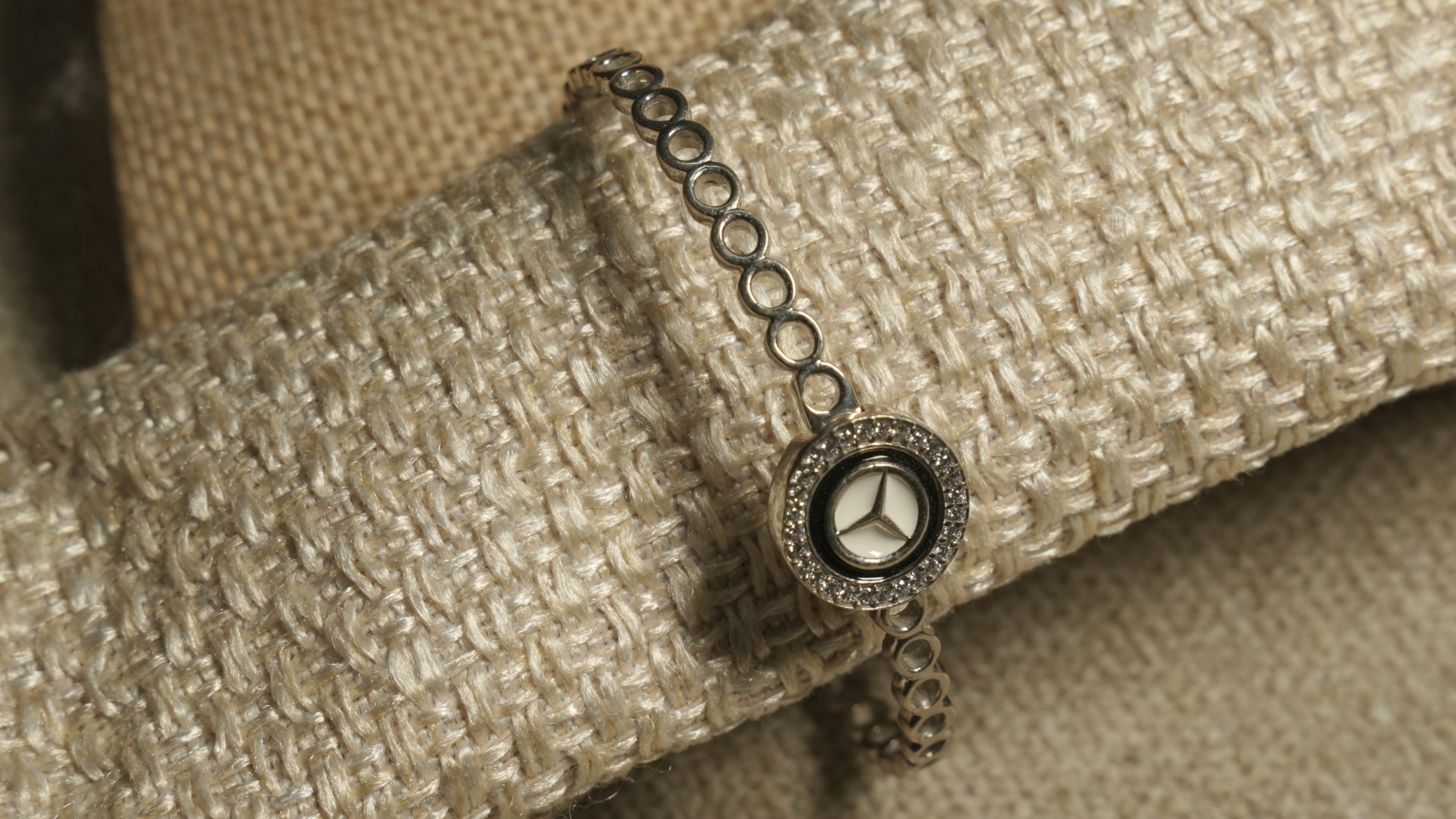 The bracelet wrapped around a fabric roll, showing the star medallion with its black enamel ring and cubic zirconia halo.