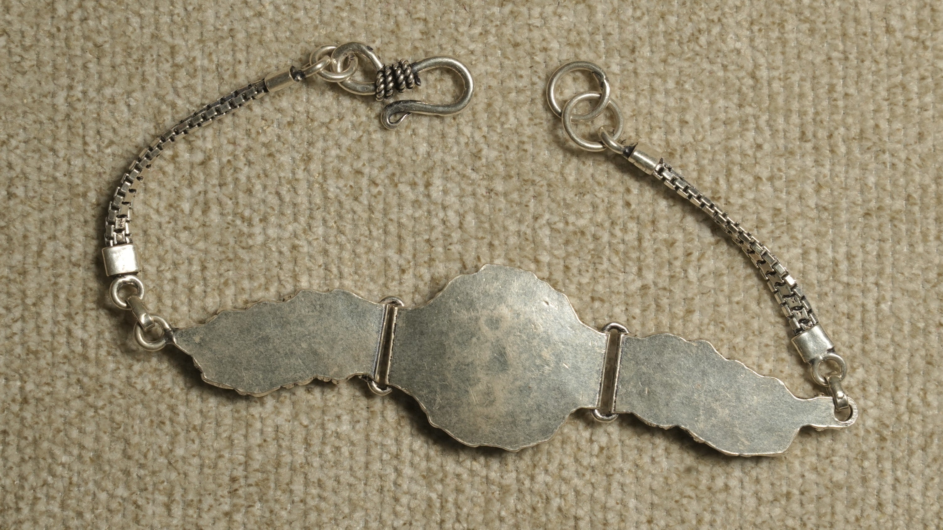 Reverse of the bracelet showing the smooth oxidised silver panel backs, twin box chaiMG and hook fastening.
