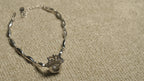 Overhead view of the full crown motif bracelet showing its slim marquise links, clasp and extender chain.