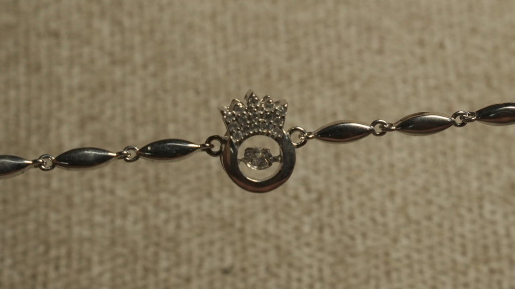 Close view of the Bejewelled crown and open circle motif with its free-moving cubic zirconia along the chain.
