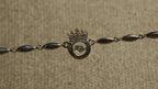 Close view of the Bejewelled crown and open circle motif with its free-moving cubic zirconia along the chain.