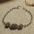 Overhead view of the bracelet showing the rose gold-tone centre cluster flanked by textured silver clusters on a fine beaded chain.