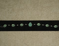 Sterling silver bracelet of prong-set sea-green oval stones with a pear-shaped centre stone, spaced by round cubic zirconia, displayed on black velvet.
