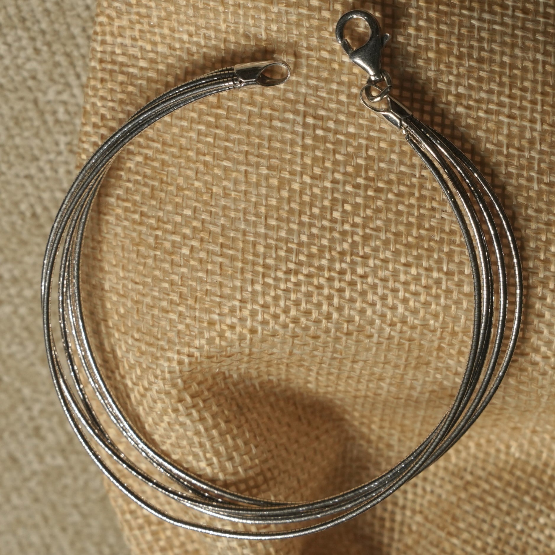textured link bracelet on beige fabric.