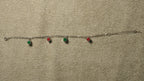 The enamel square bracelet laid out straight, showing its four coloured squares, chain and extender.