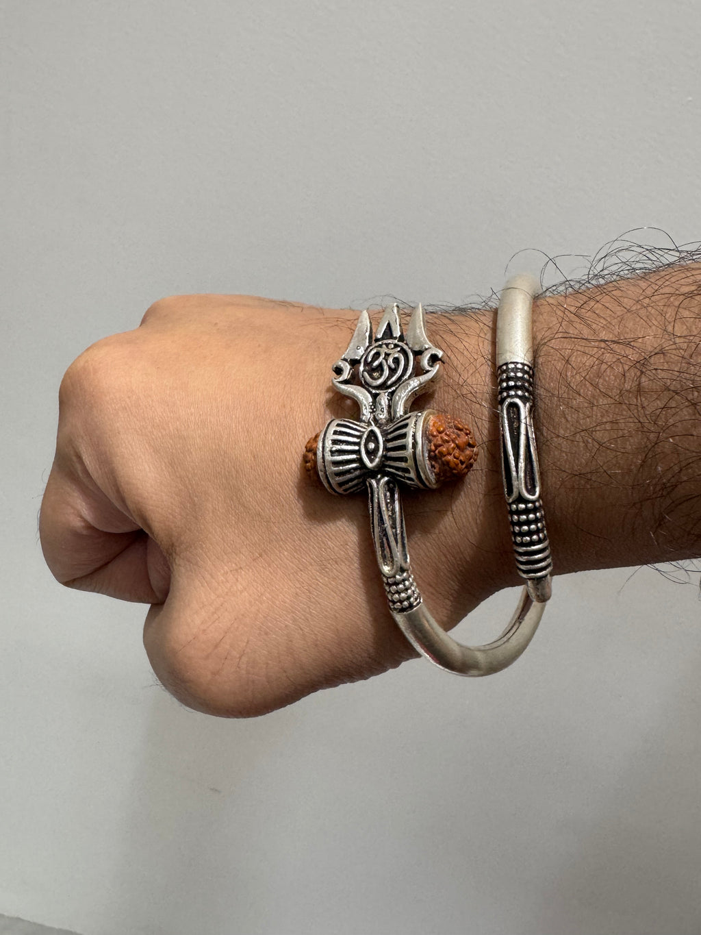 Sterling silver trishul and rudraksha kada worn on a wrist, the trishul sitting across the back of the hand.
