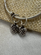 Close view of the two oxidised leaf drops and their jump rings on the sterling silver bangle.