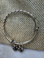 Sterling silver bangle on jute, showing the sliding ends and the bead stoppers that hold the size.