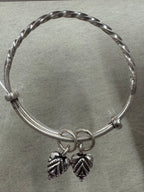 Sterling silver adjustable bangle showing the twisted section meeting the plain round ends at the collars.