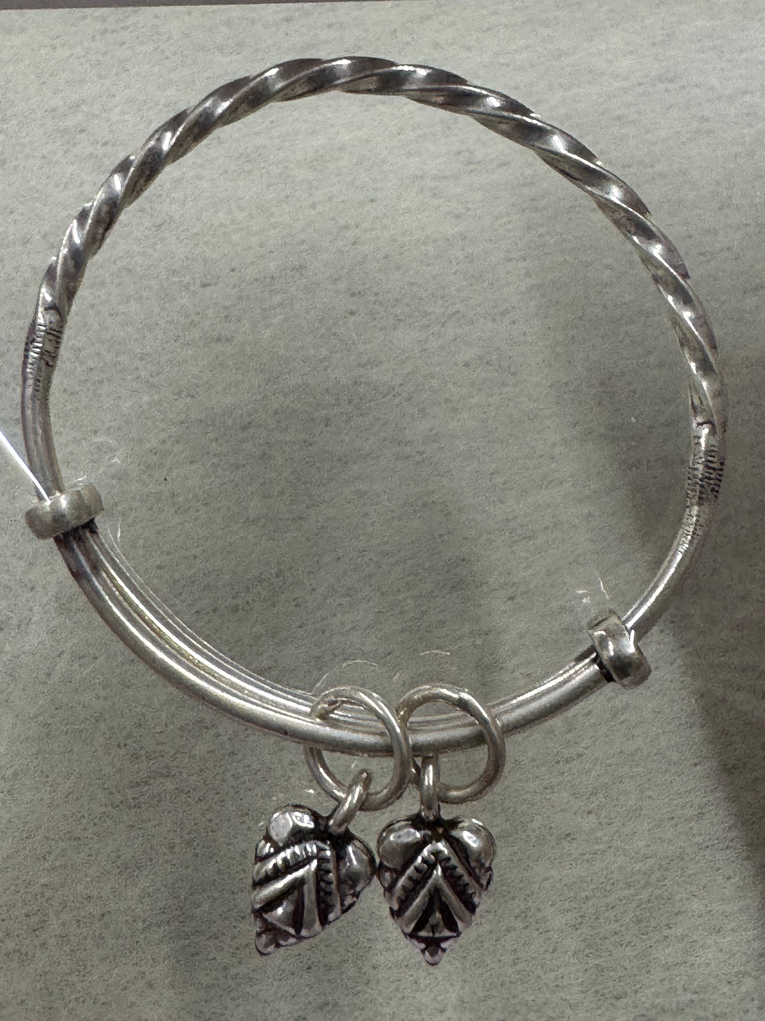 Sterling silver adjustable bangle showing the twisted section meeting the plain round ends at the collars.