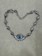 Overhead view of the sterling silver nazar bracelet, with the heart tag stamped 925 at the end of the extender chain.