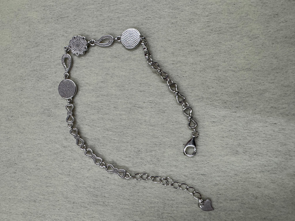 Reverse of the sterling silver bracelet arranged in a curve, showing the dotted backs of the three stations.