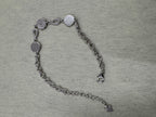 Reverse of the sterling silver bracelet arranged in a curve, showing the dotted backs of the three stations.