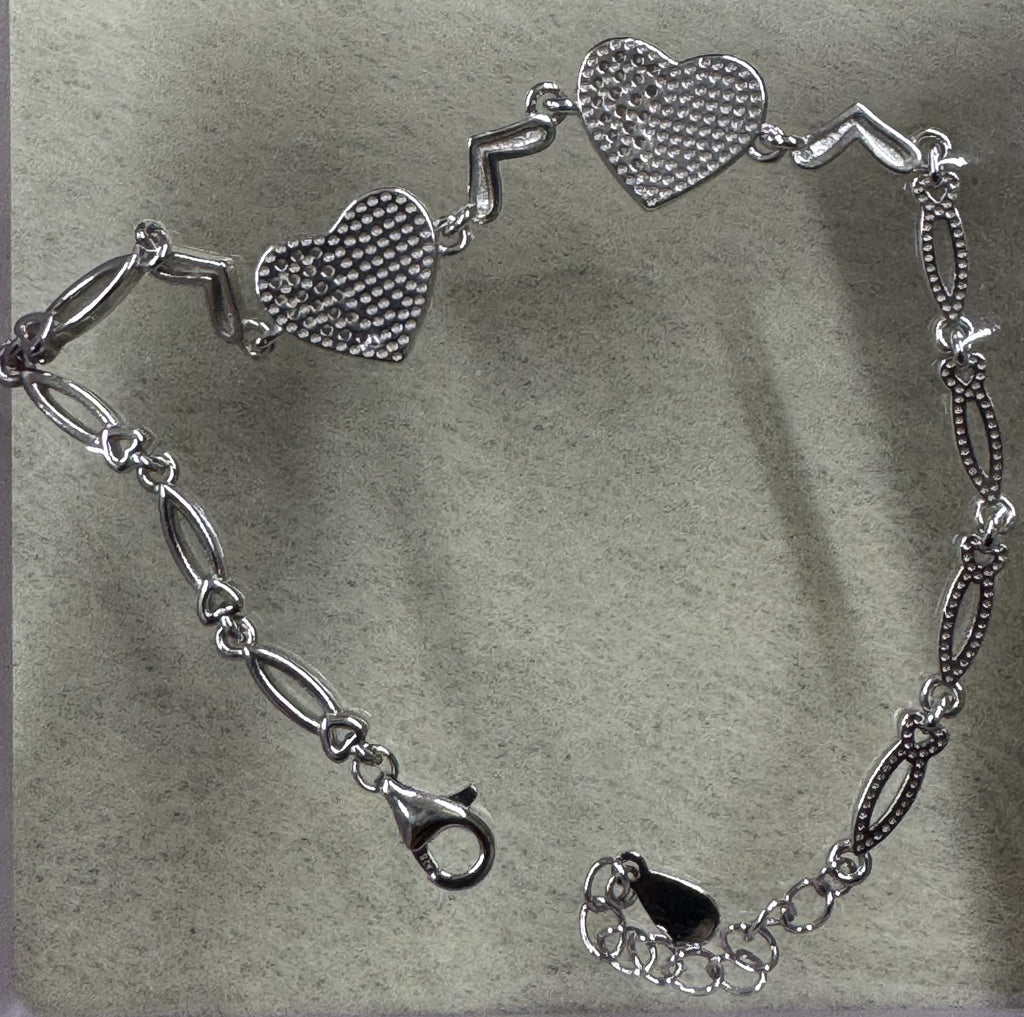 Reverse of the sterling silver heart bracelet, showing the pierced dotted backs of the two heart stations.