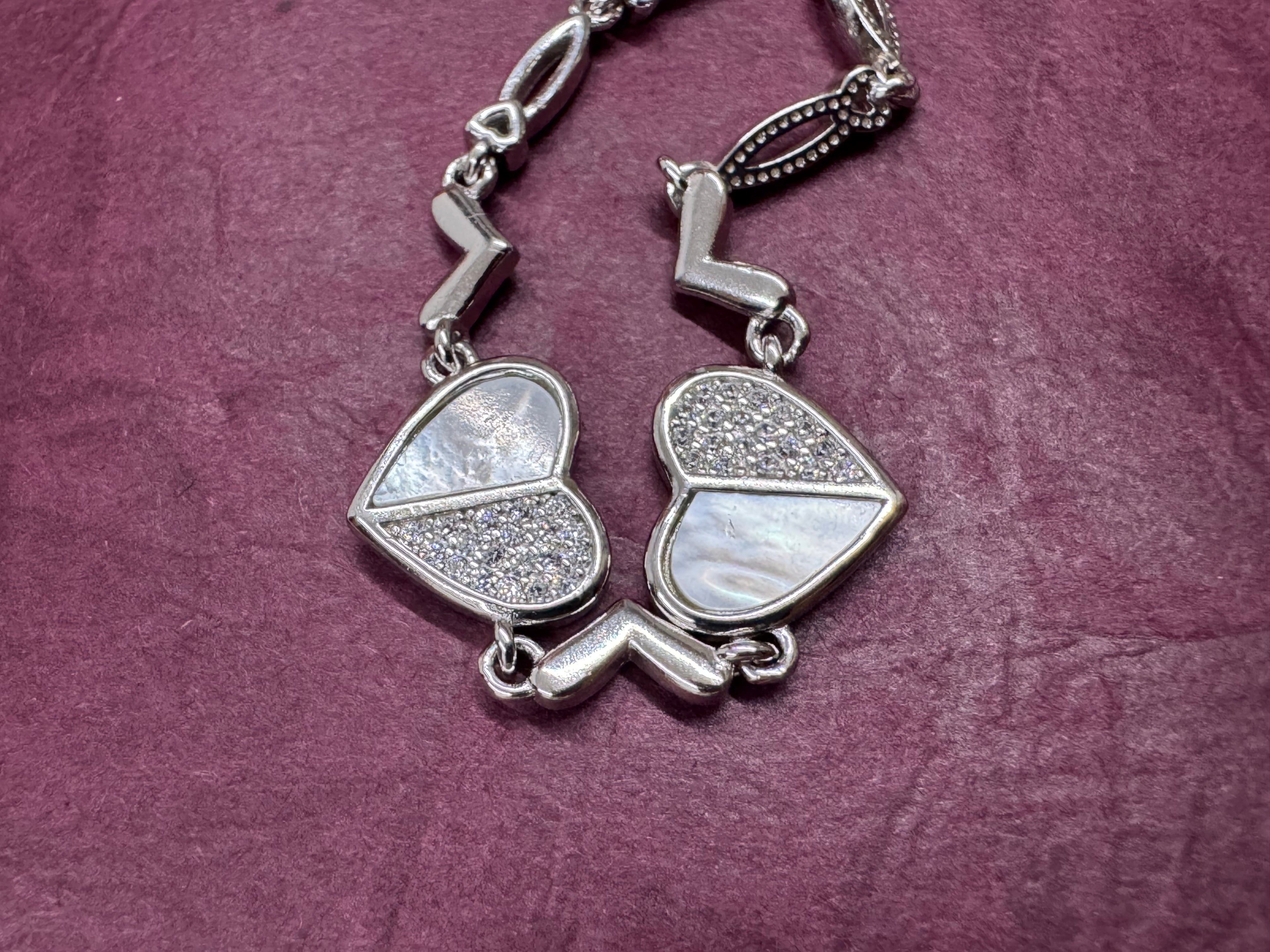 Close view of the two sterling silver heart stations, one half of each heart pavé-set with cubic zirconia.