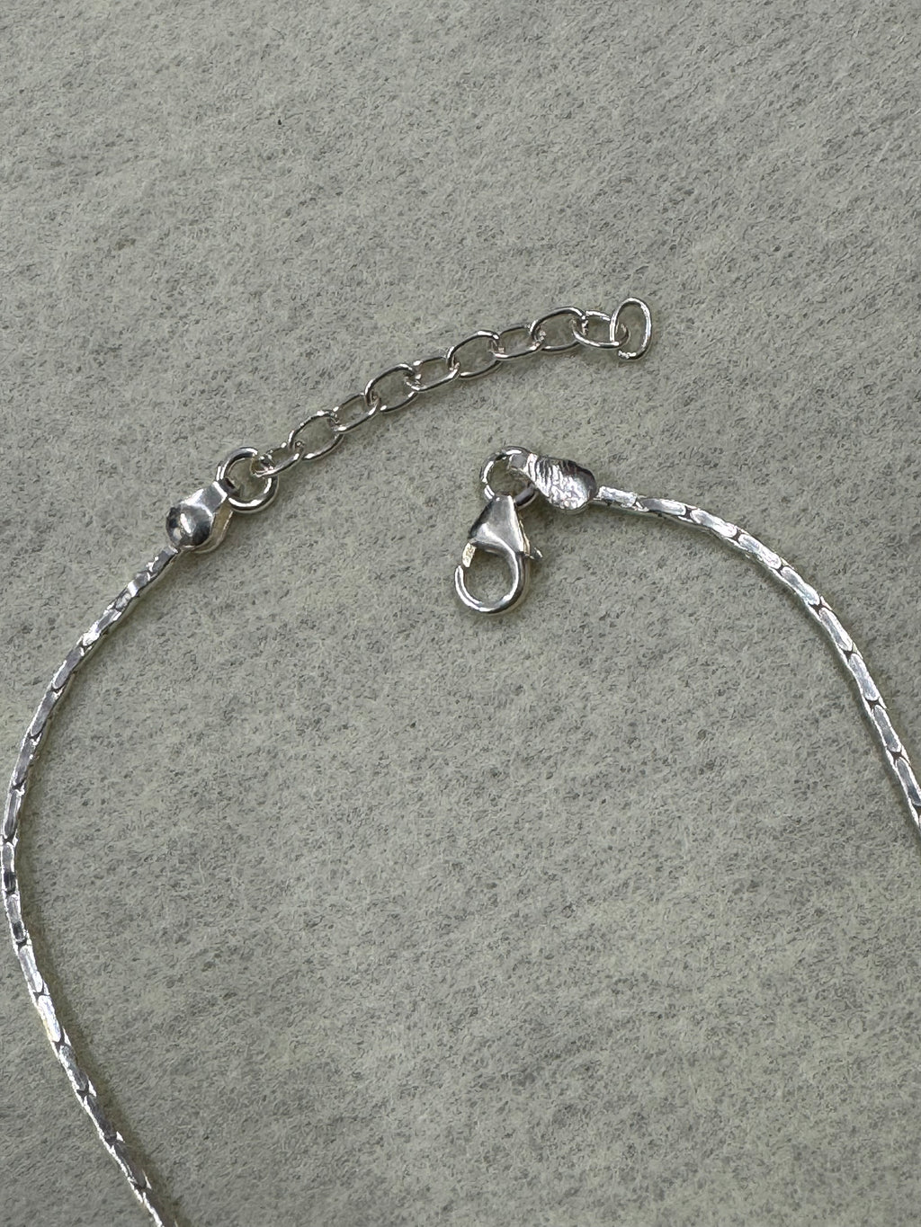 Lobster clasp and extender chain on the fine flat sterling silver chain.