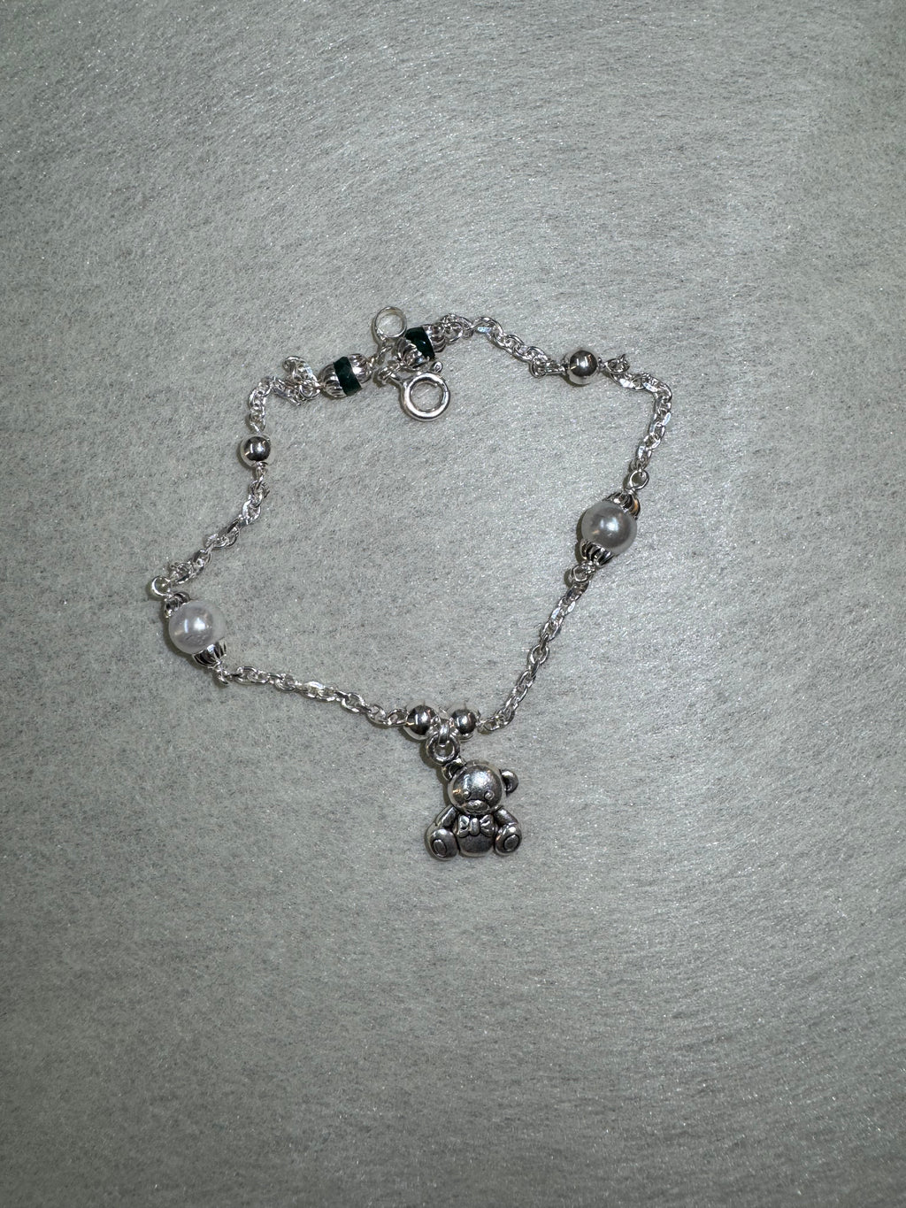 Full overhead view of the sterling silver bracelet, with two larger round beads spaced along the diamond-cut cable chain.
