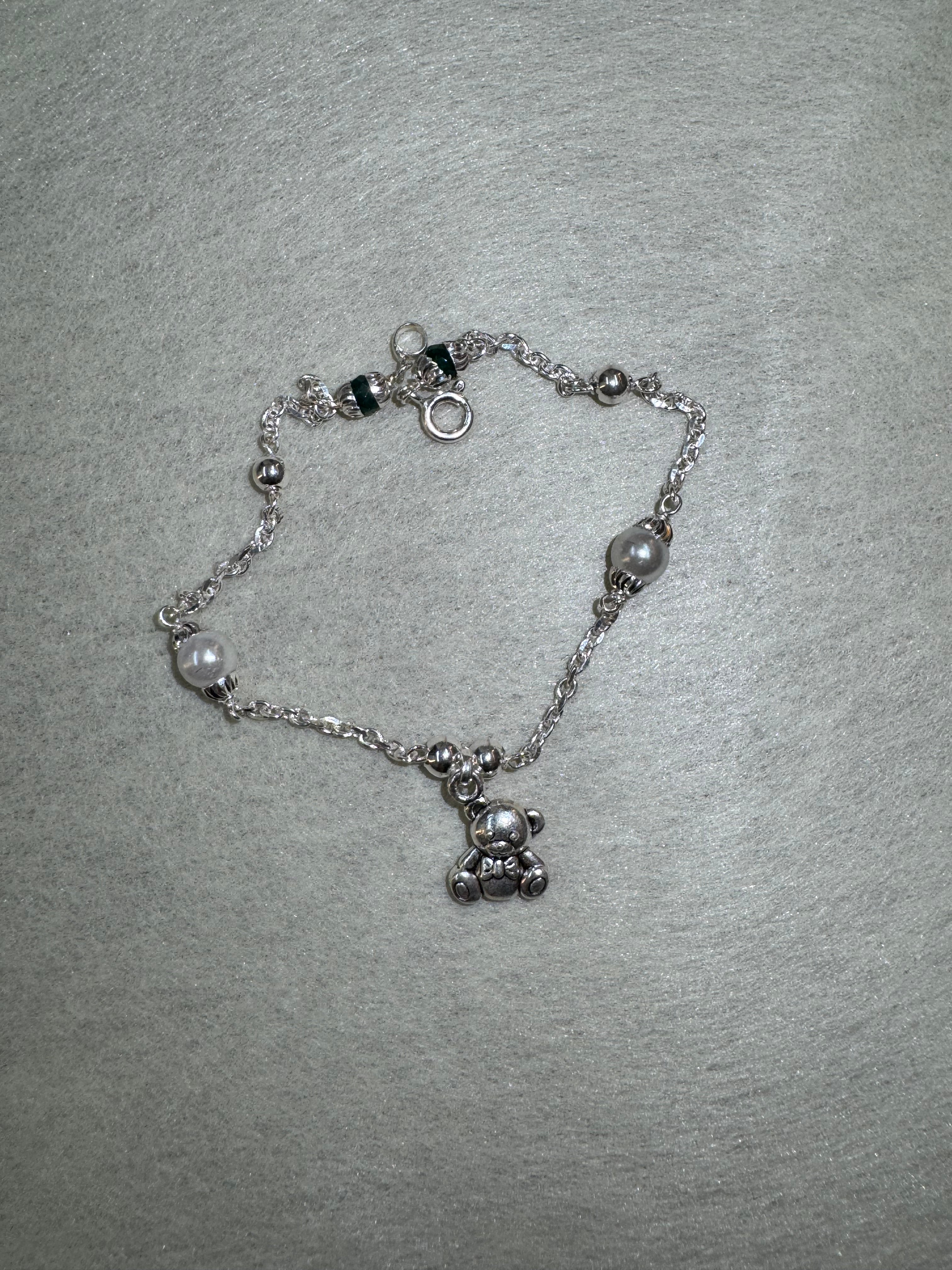 Full overhead view of the sterling silver bracelet, with two larger round beads spaced along the diamond-cut cable chain.