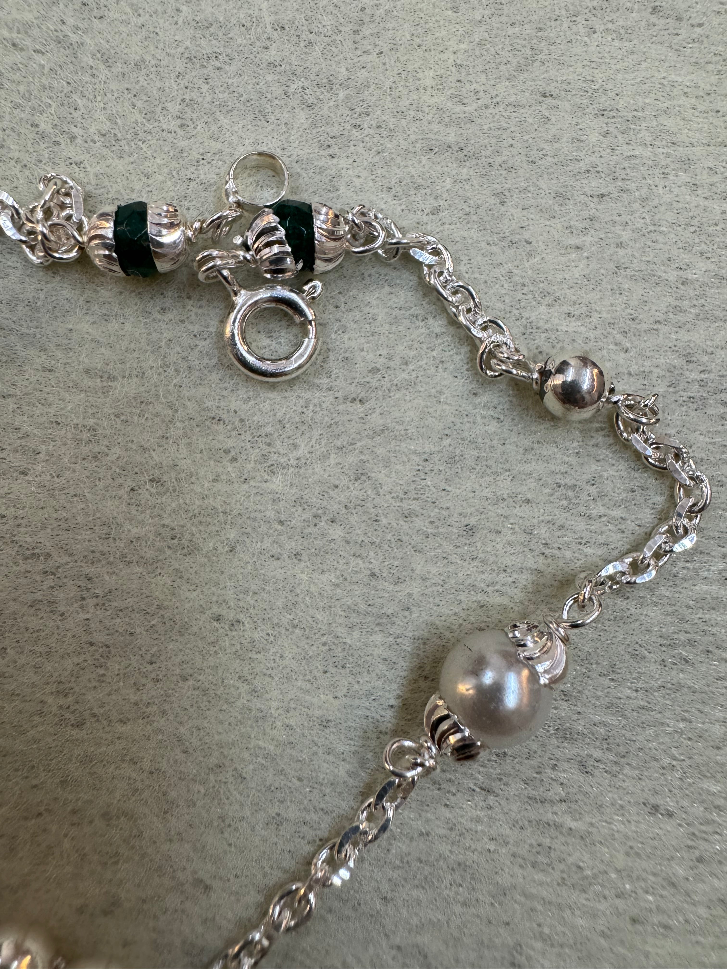 Close view of the spring ring clasp and the fluted silver beads on the sterling silver charm bracelet.