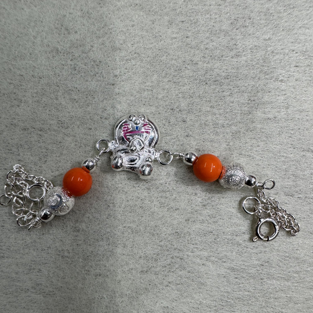 The sterling silver cat bracelet laid out straight on grey felt, showing the bead stations either side of the cat and the spring ring clasp.