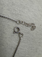 Spring ring clasp and short extender chain on the sterling silver bracelet, with the fine diamond-cut chain running to each side.