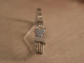 Sterling silver bracelet with a pave set American Diamonds butterfly on a three rail band with rose-tone bars.