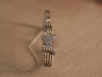 Sterling silver bracelet with a pave set American Diamonds butterfly on a three rail band with rose-tone bars.