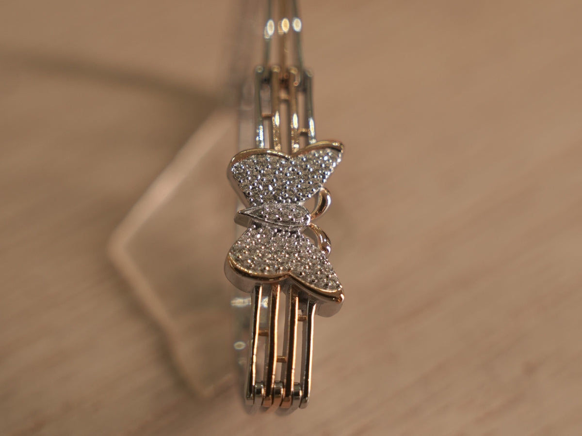 Close view of the American Diamond butterfly, showing the pave wings and the open rail band.