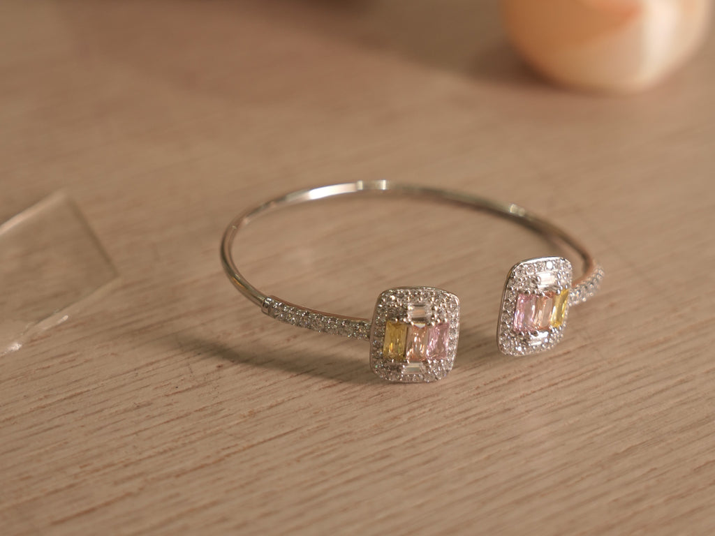 Slim sterling silver open cuff with two cushion clusters of yellow, pink and colourless baguette American Diamonds.