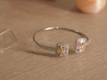 Slim sterling silver open cuff with two cushion clusters of yellow, pink and colourless baguette American Diamonds.