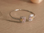 Close view of a pastel baguette cluster on the silver cuff, framed by a pave halo.