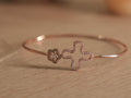 Slim rose-tone wire bracelet with an open clover outline traced in American Diamonds and a small pave flower.
