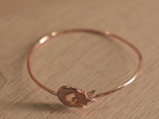 Close view of the crescent and star motif on the rose-tone bracelet.