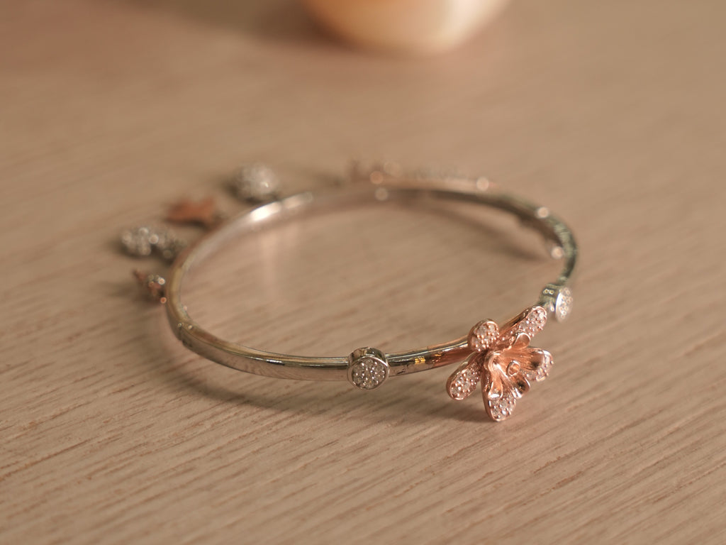 Slim sterling silver bracelet with sculpted rose-tone lilies and pave set American Diamonds discs.