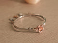 Slim sterling silver bracelet with sculpted rose-tone lilies and pave set American Diamonds discs.