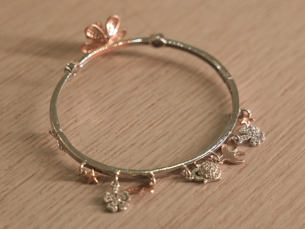The lily bracelet at an angle, showing the alternating flowers and stone set discs.