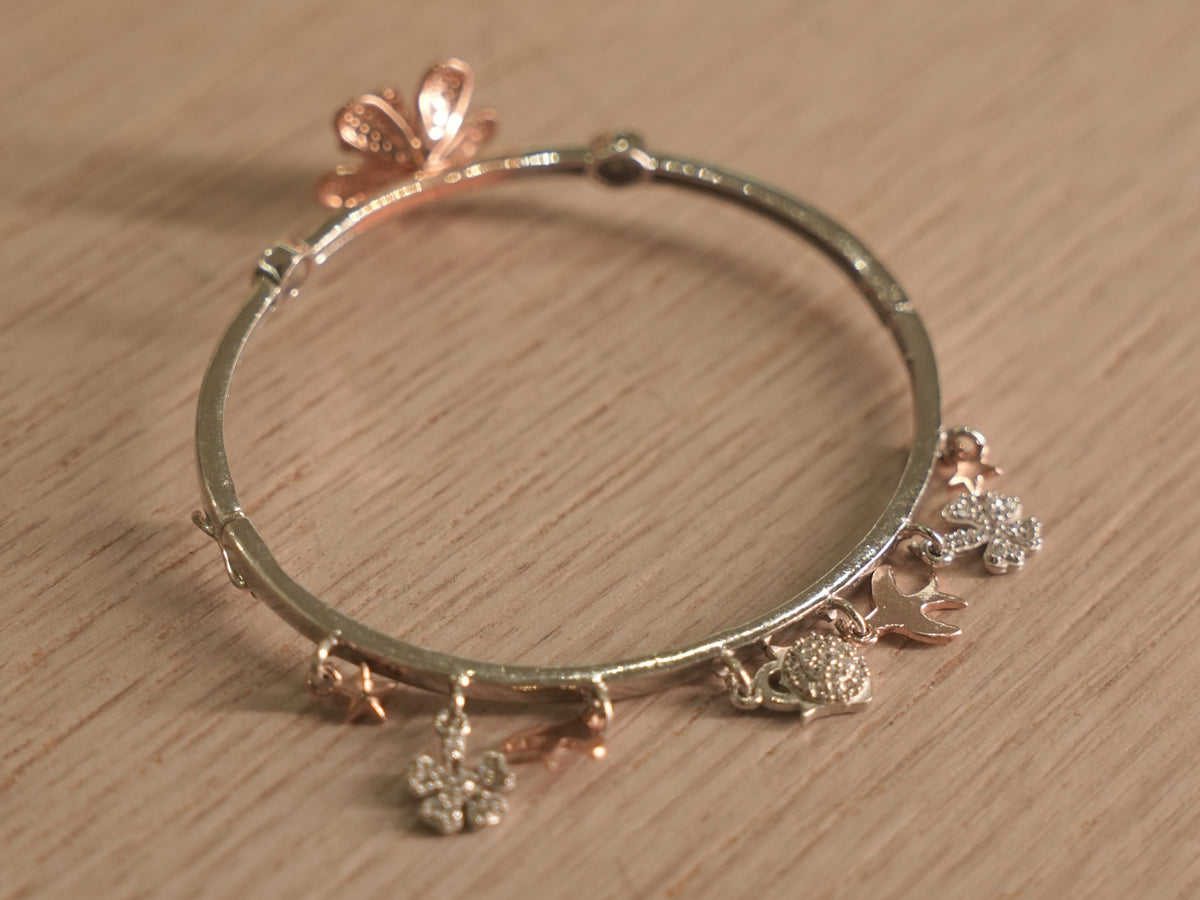 The lily bracelet at an angle, showing the alternating flowers and stone set discs.