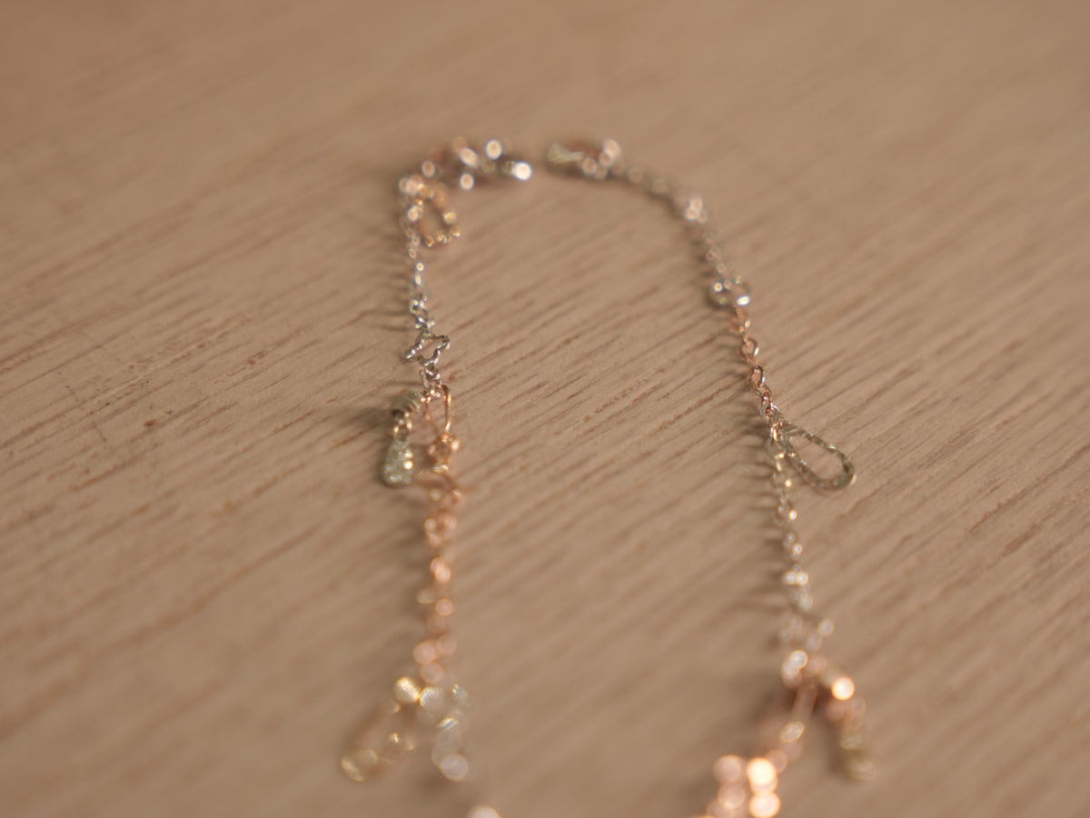 The starburst link bracelet laid open, showing the alternating silver and rose-tone links.