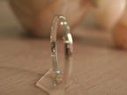 The plain silver kada lying flat, showing its continuous rounded band.
