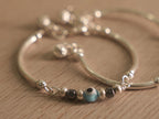 Two matching baby silver nazariya bangles with evil eye beads and ghungroo drops, shown together.