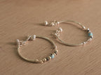 Both baby nazariya bangles resting together on a pale wooden surface.