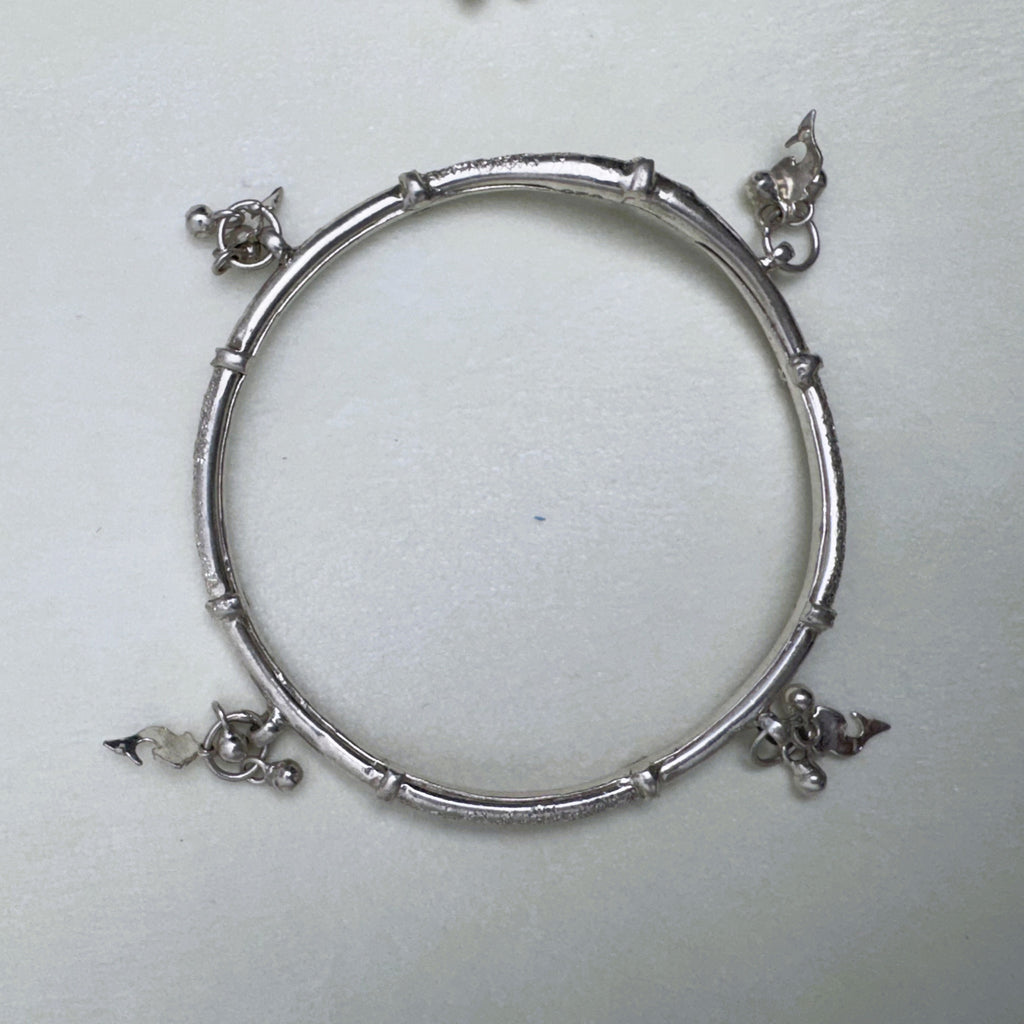 The silver kada seen from above, showing the four charm points around the ring.