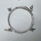 The silver kada seen from above, showing the four charm points around the ring.