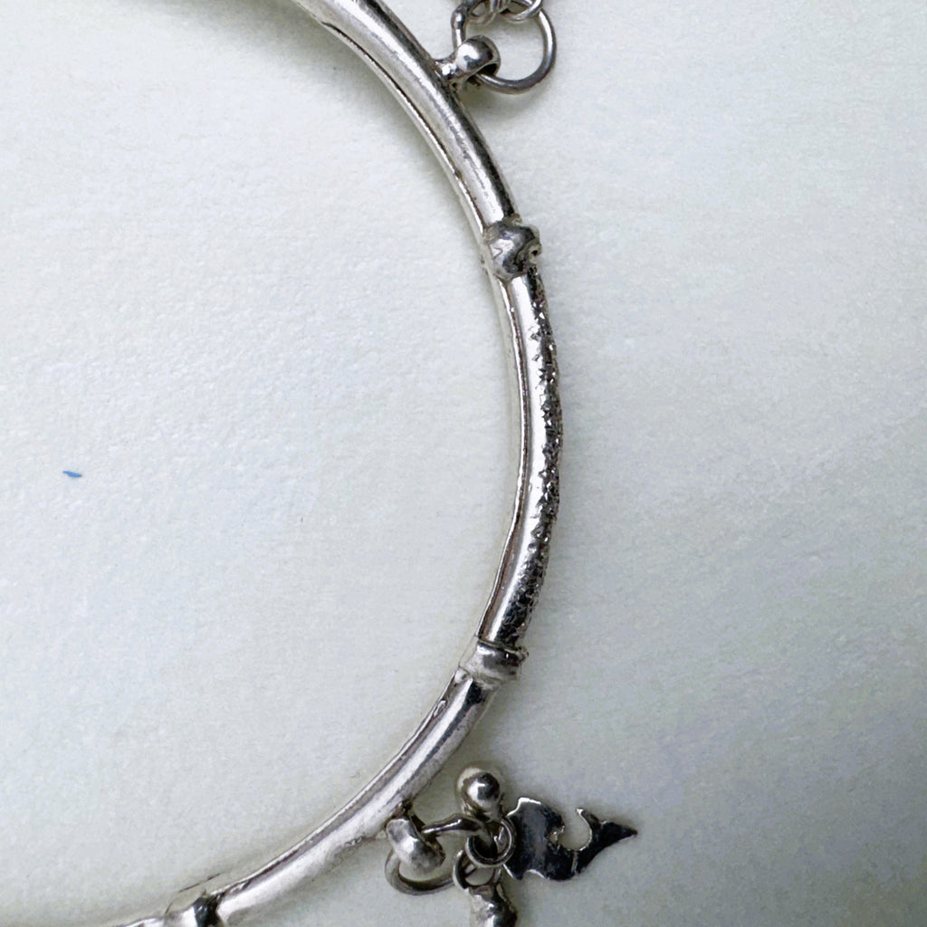 Close view of the diamond-cut section between two polished lengths of the kada.