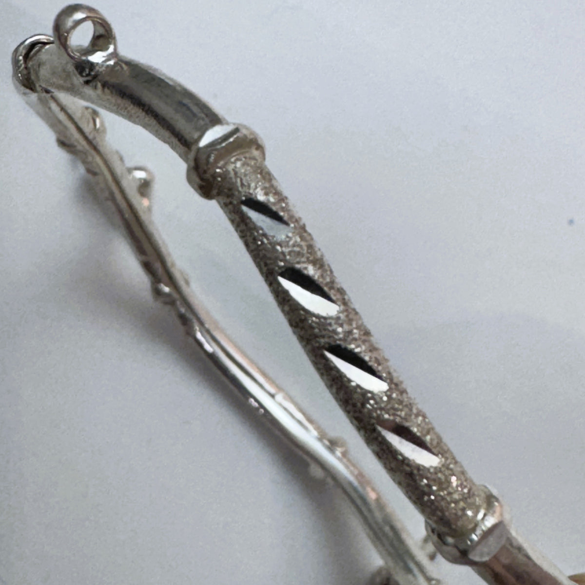 Close view of the two tubes of the kada and the diamond-cut texture.